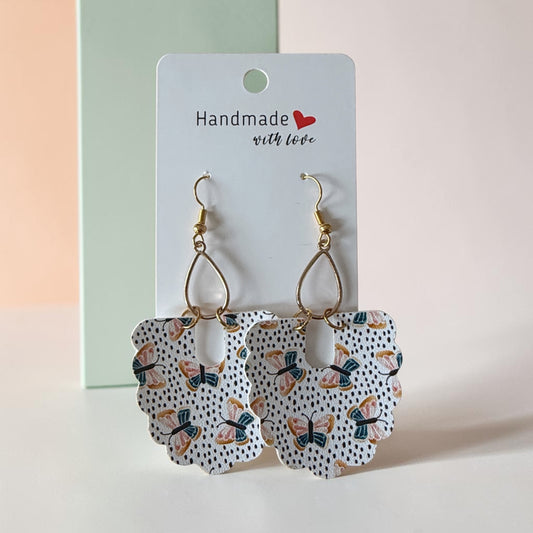 Roselee Glitz handmade drop earrings featuring a butterfly pattern on a dotted background with gold-tone hardware.