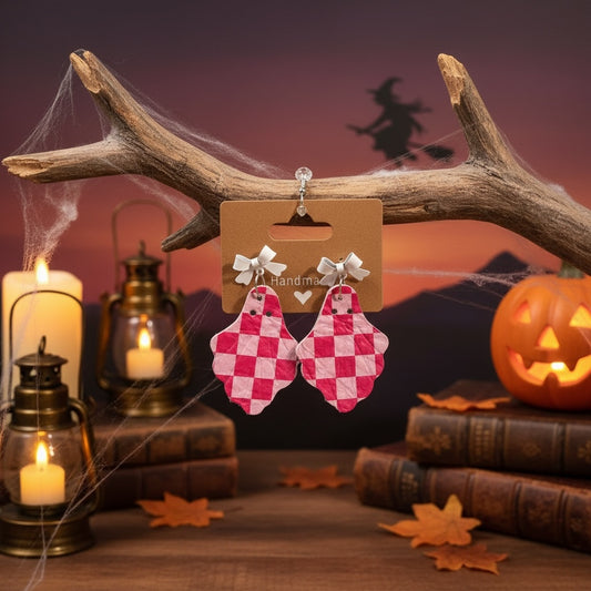 Roselee Glitz pink and white checkered ghost dangle earrings with white bows, displayed on a rustic Halloween backdrop.