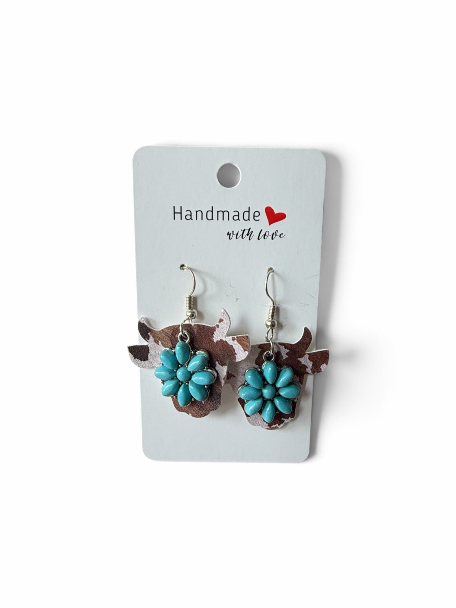 Roselee Glitz cow-shaped dangle earrings with brown and white cow print and turquoise floral accents on a display card.
