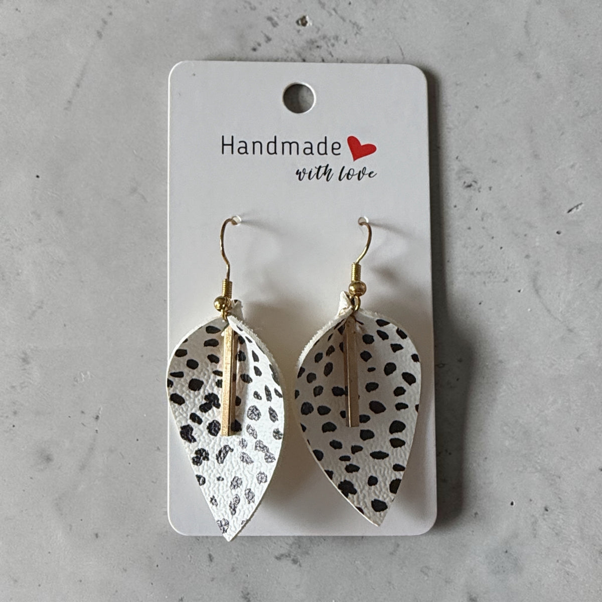 Roselee Glitz handmade leaf-shaped faux leather drop earrings with a black and white dalmatian print and gold bar.