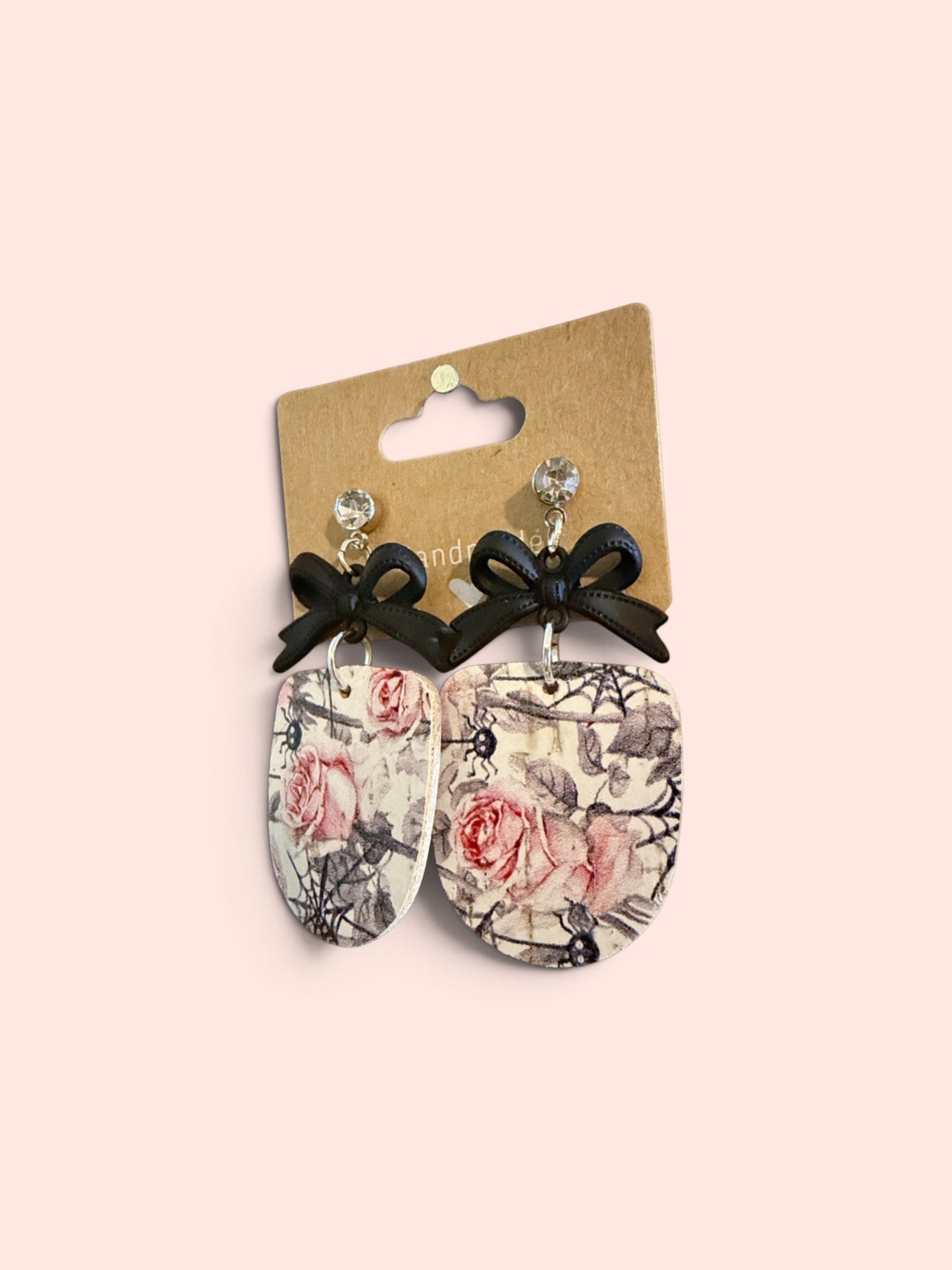 Roselee Glitz floral drop earrings featuring a rose and spiderweb print, black ribbon bows, and crystal studs.