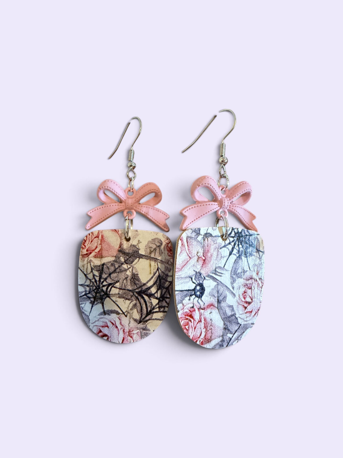 Roselee Glitz drop earrings featuring oval pendants with vintage rose and spiderweb prints and pastel pink bow accents.