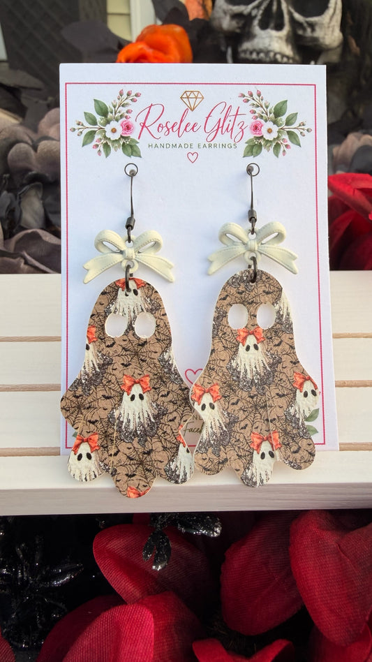 Roselee Glitz ghost-shaped dangle earrings with spiderweb pattern, orange bows, and cream-colored bow accents.