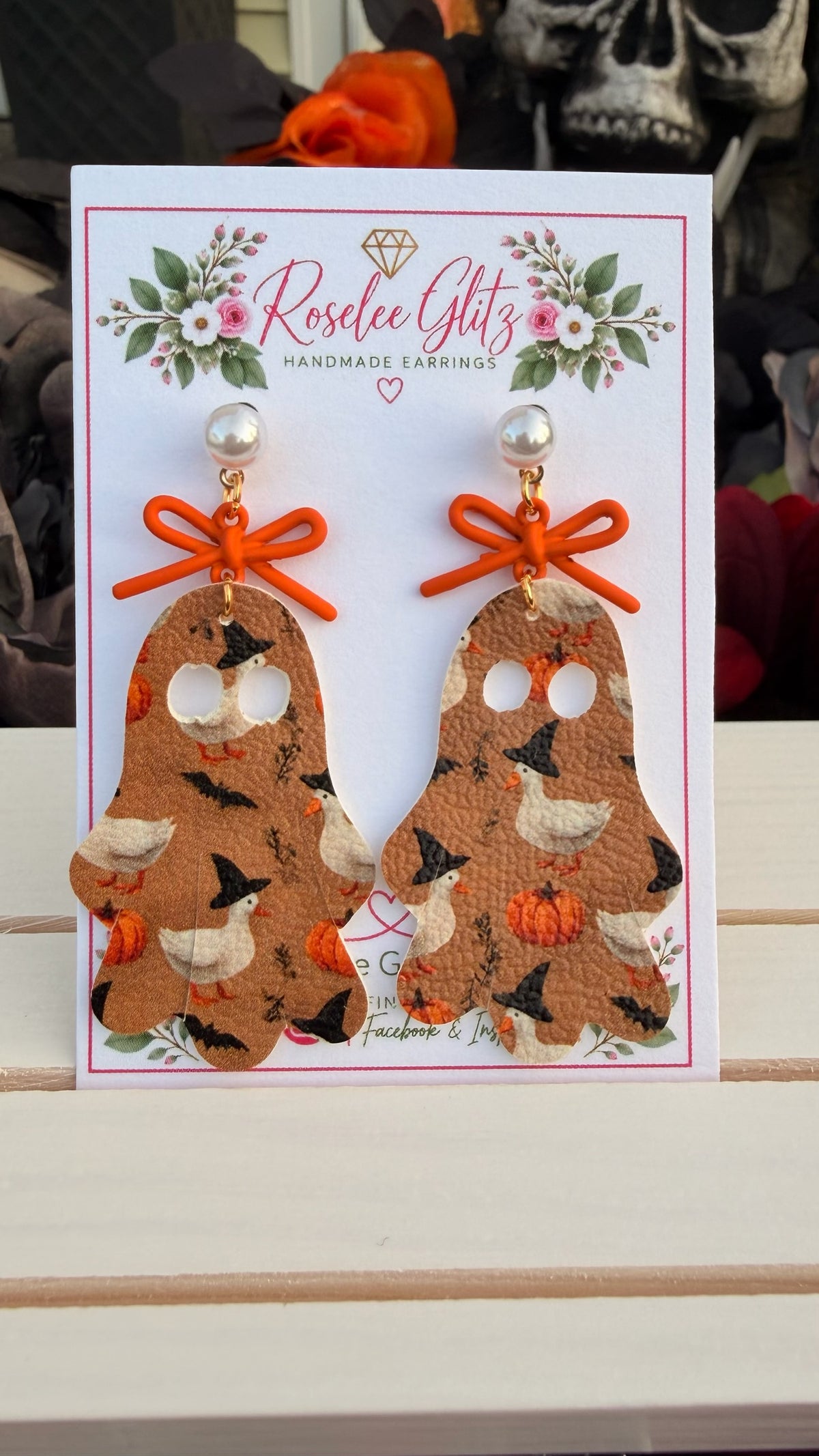 Roselee Glitz ghost-shaped faux leather dangle earrings featuring witch-hat ducks, pumpkins, and orange bows.