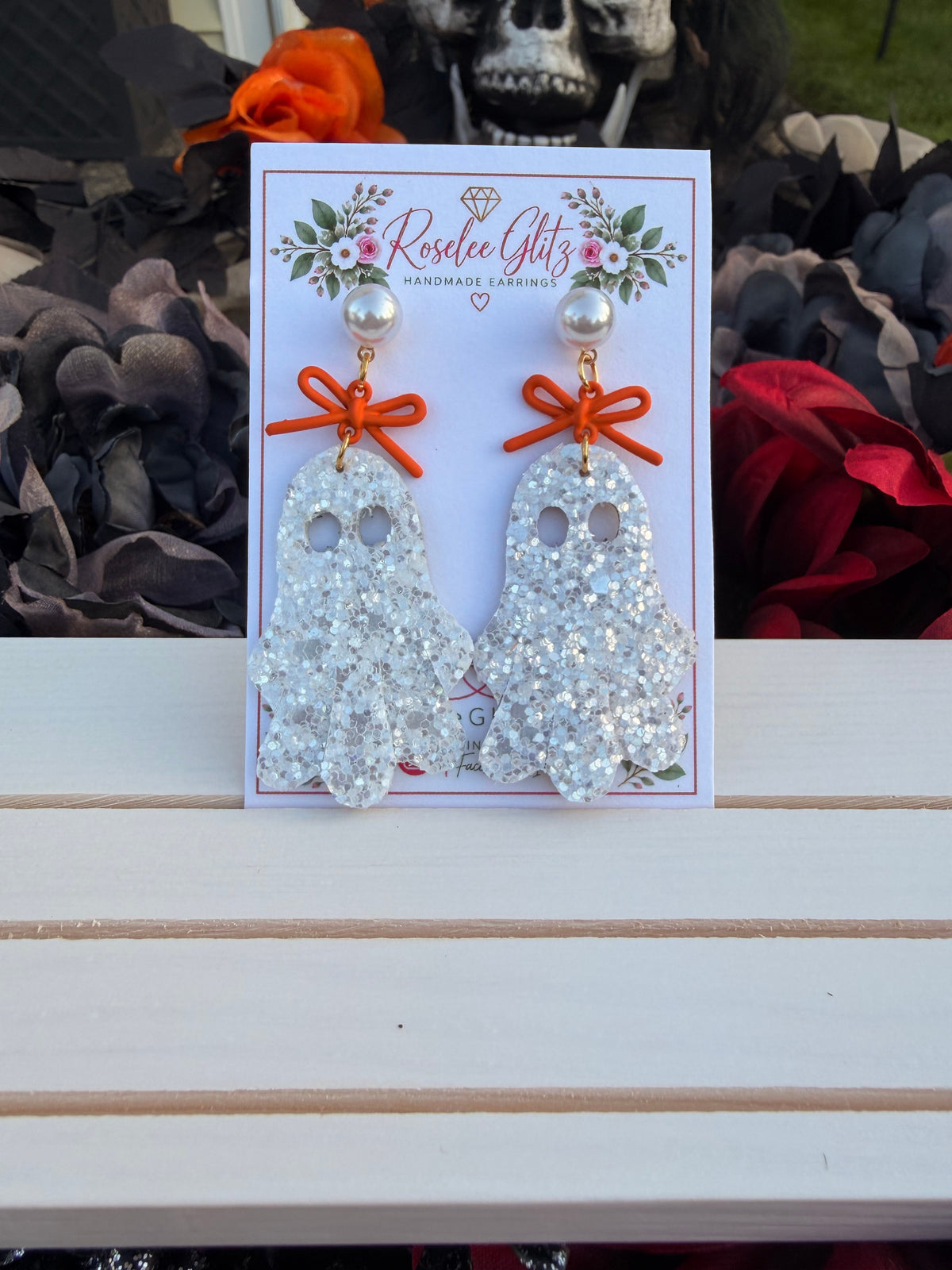 Roselee Glitz glitter ghost dangle earrings with orange bows and pearl studs on a branded display card