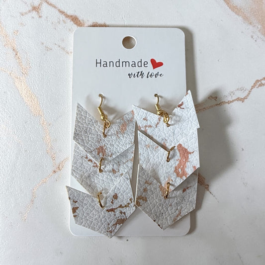 Roselee Glitz layered arrow drop earrings in white faux leather with rose gold metallic marble pattern and gold hooks.
