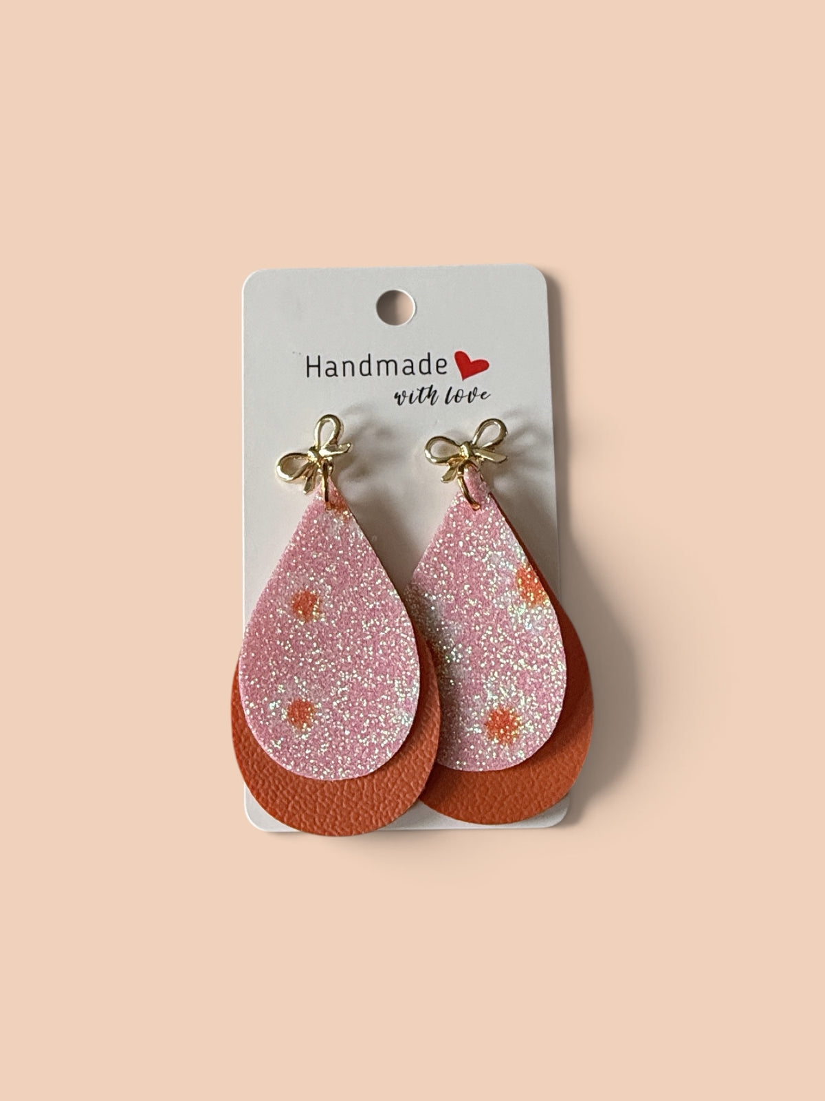 Roselee Glitz layered teardrop dangle earrings featuring glittery pink floral tops and solid terracotta bases with bows