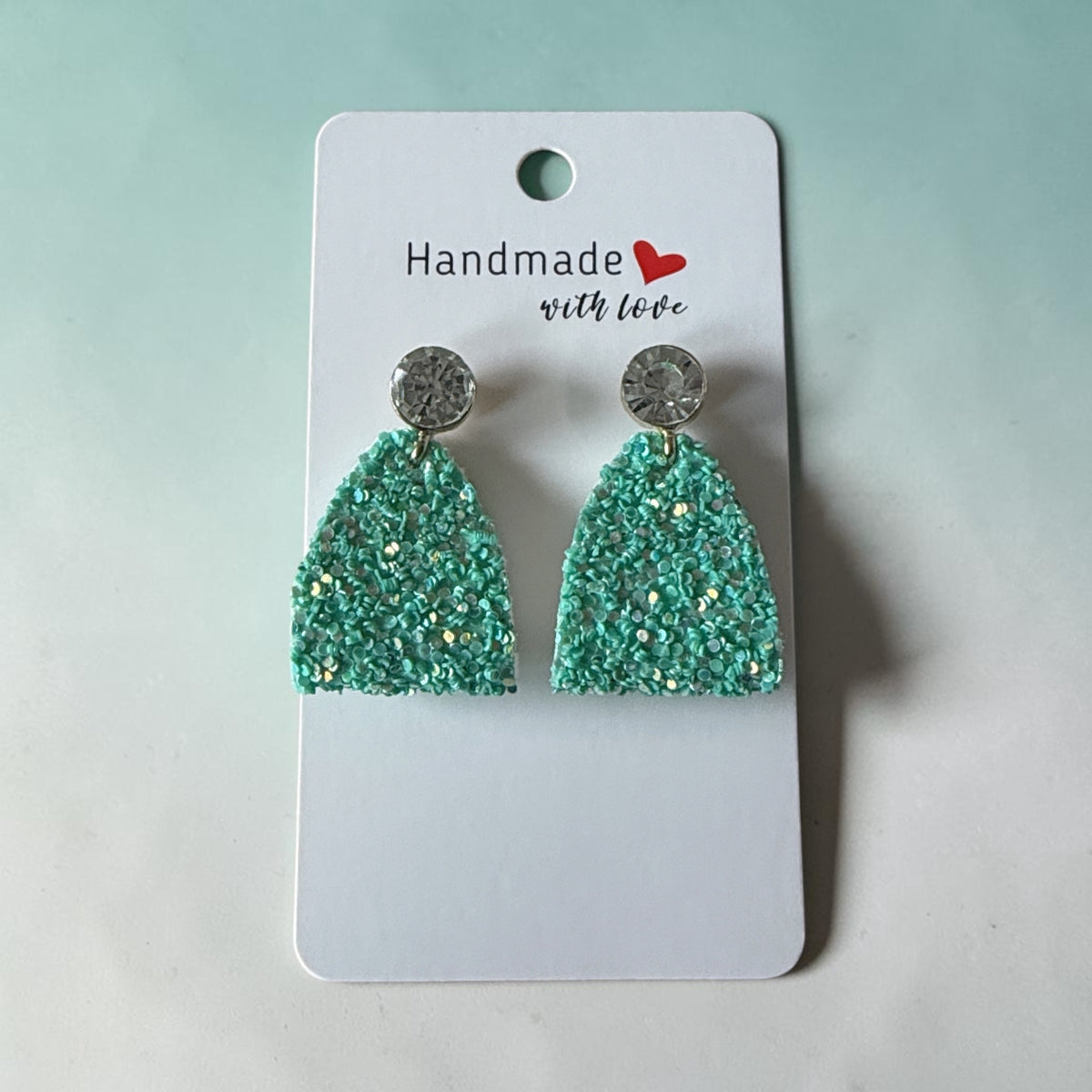 Roselee Glitz mint green glitter arch-shaped dangle earrings with sparkling crystal stud tops on a display card.