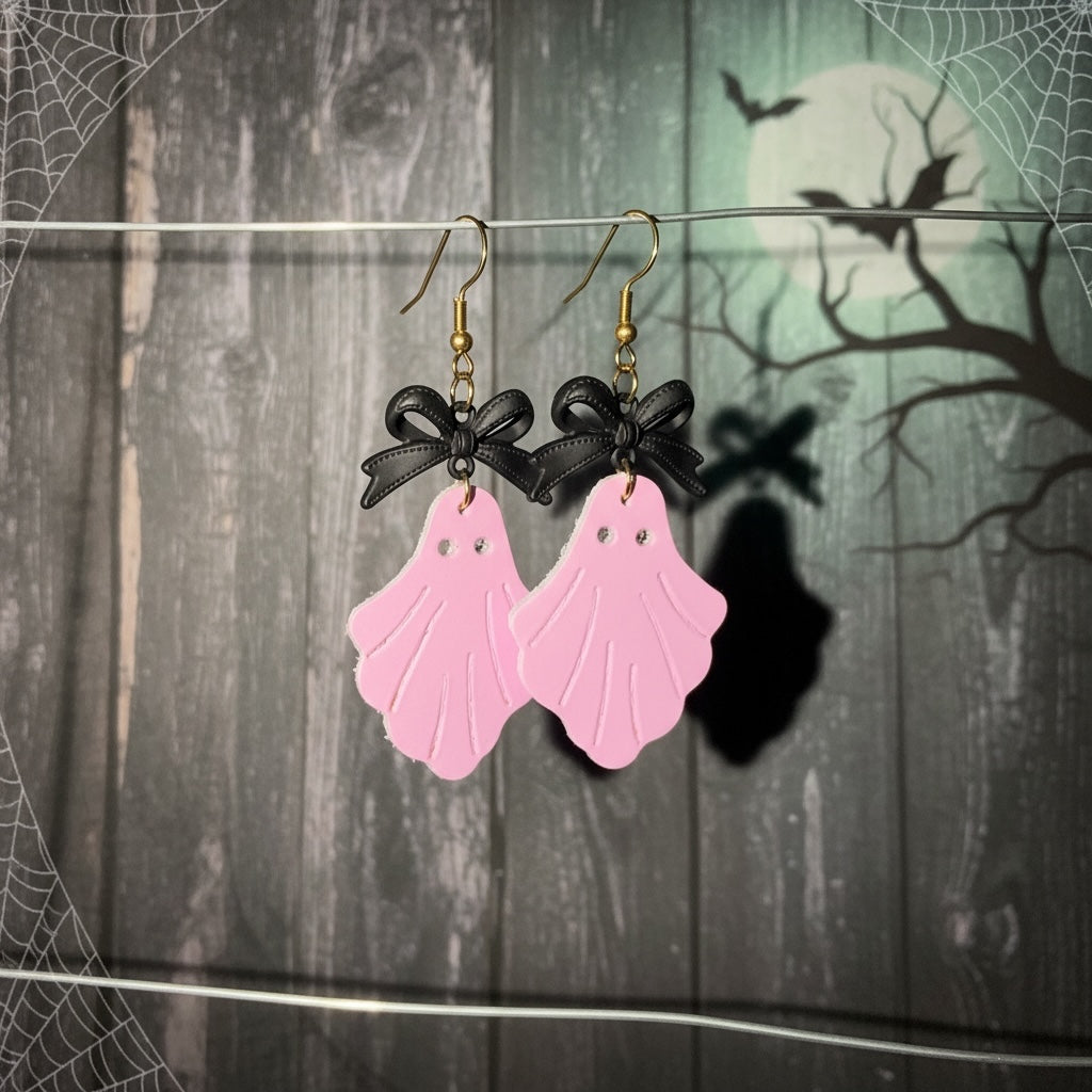 Roselee Glitz pastel pink faux leather ghost dangle earrings with black bows and gold-toned fishhook wires.