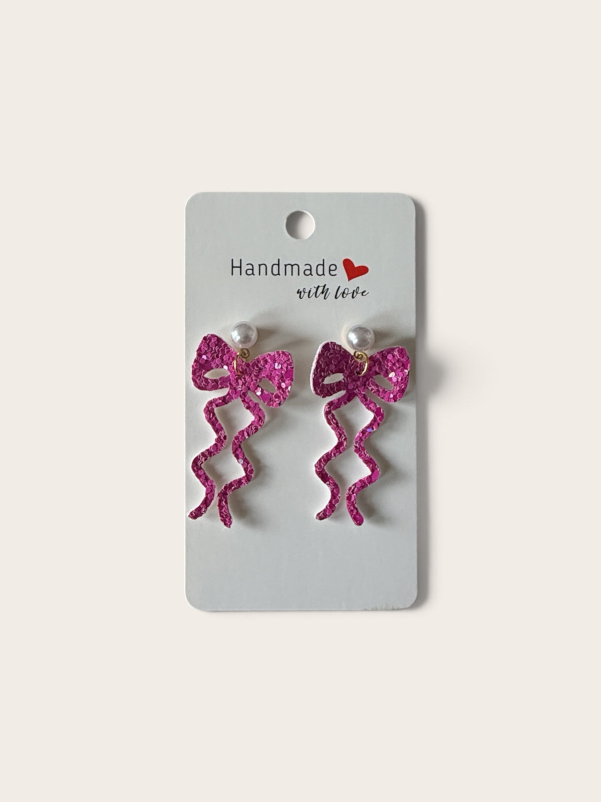 Roselee Glitz handmade hot pink glitter ribbon bow dangle earrings with faux pearl studs on a display card