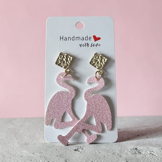 Roselee Glitz pink glitter flamingo dangle earrings with textured gold-tone square studs on a display card